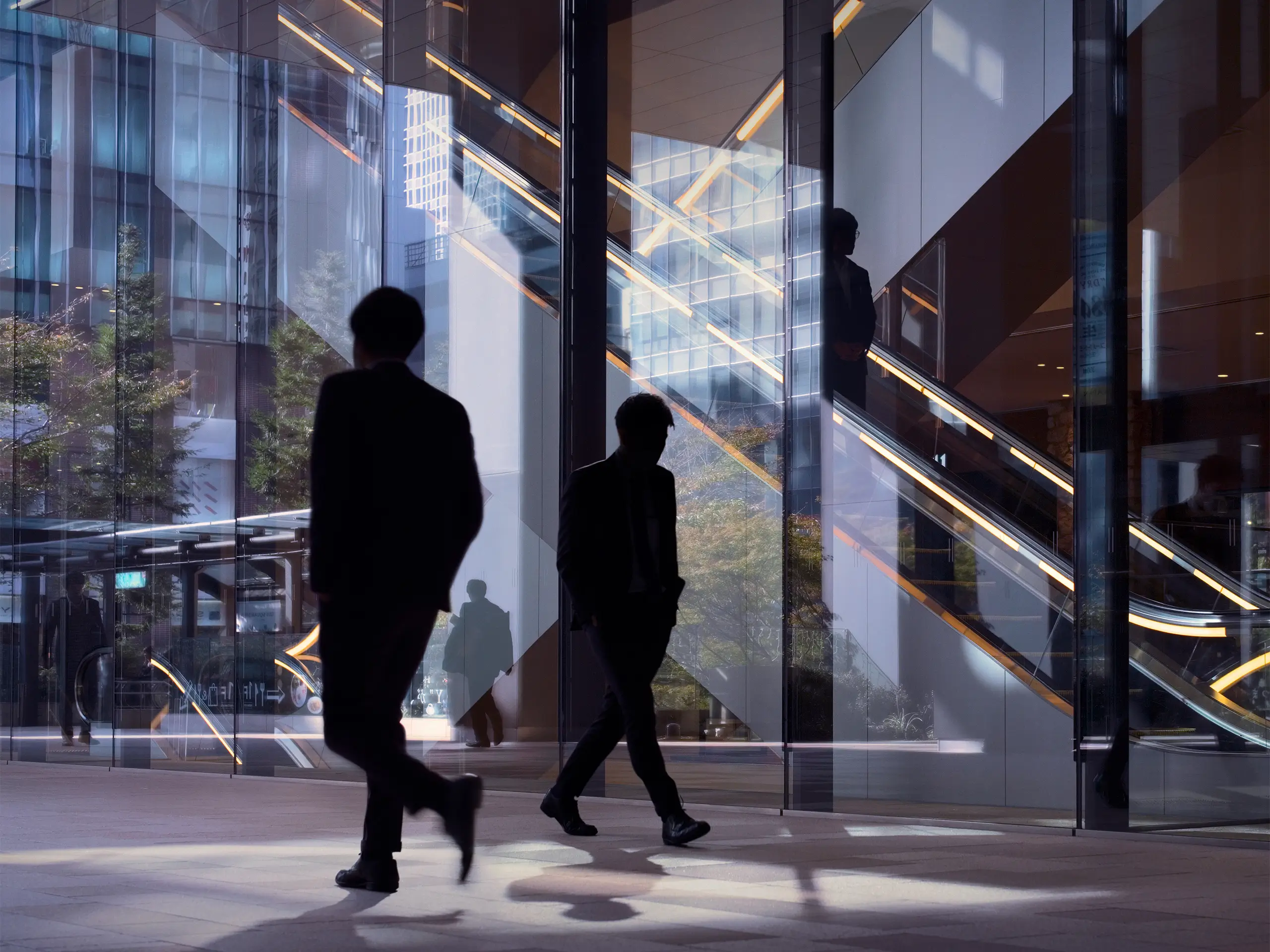 Modern office facade with silhouettes of passing office workers